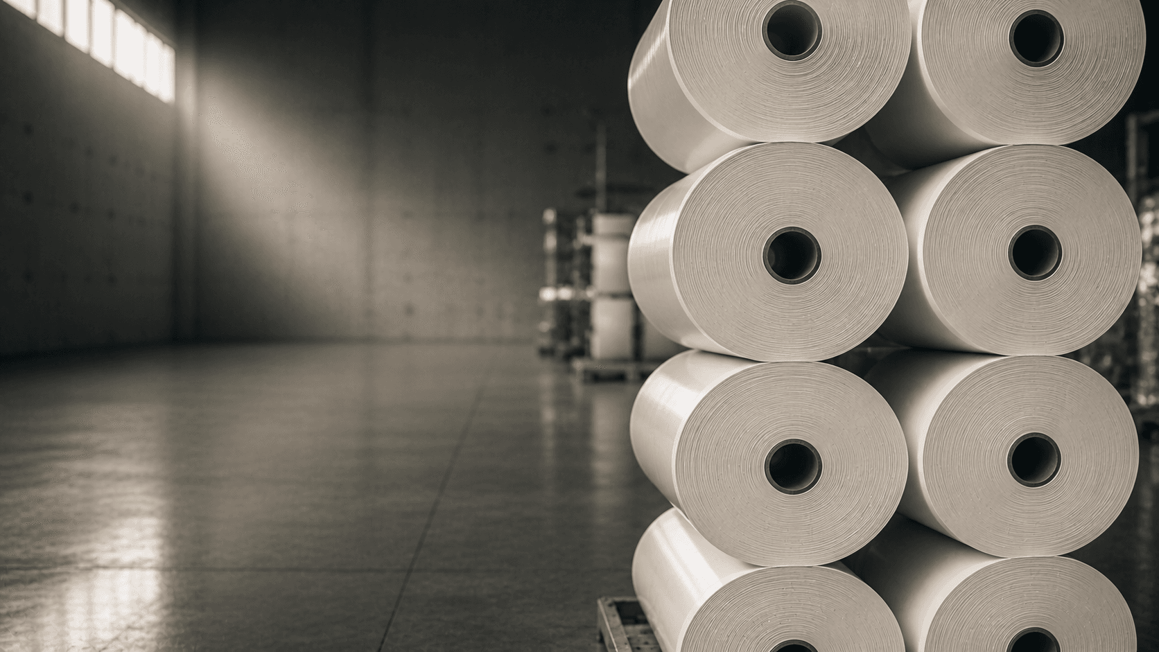 Column of cylindrical thermal paper rolls stacked on a kraft surface